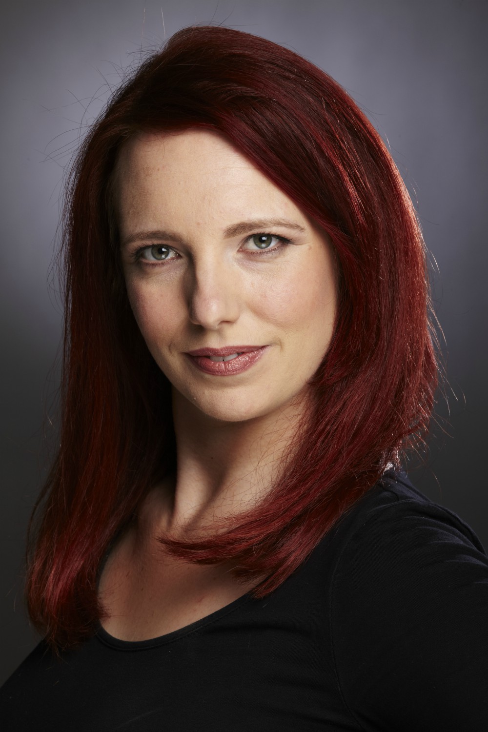 Colour studio shot of Gillian Dean with bright red hair