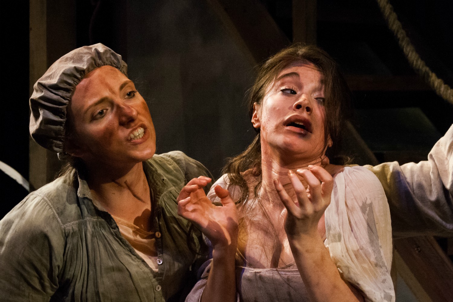 Gillian Dean as Sal in Bedlam. She wears a dirty mob cap and blouse. Gillian is grabbing a young lady by the hair.